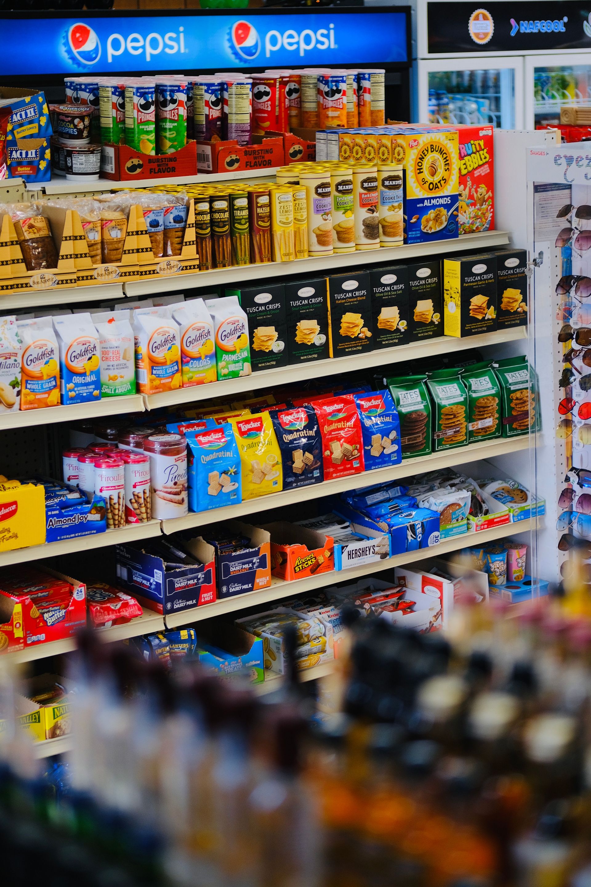 A vibrant display of snacks and beverages on shelves in a store, showcasing variety and abundance.