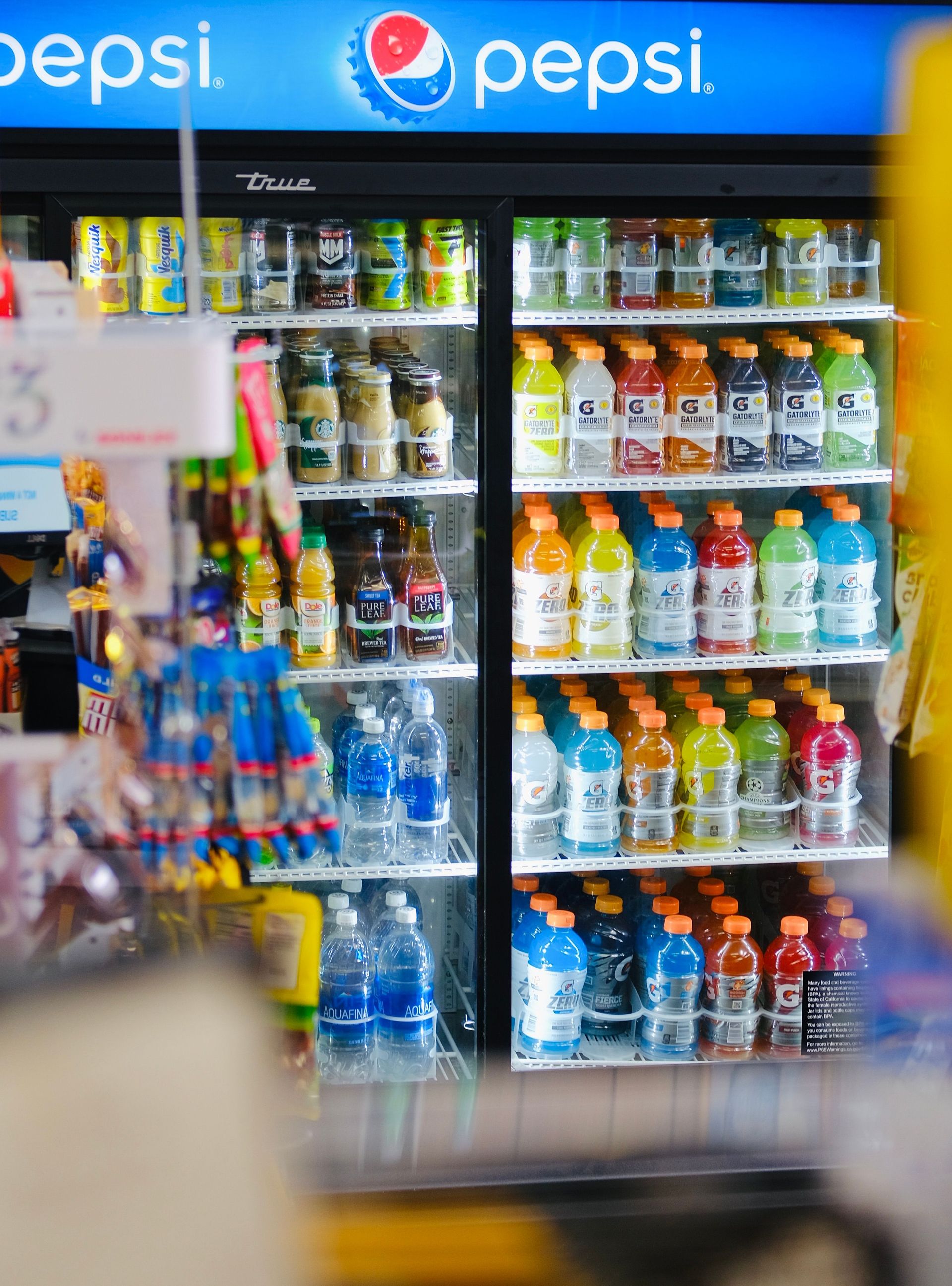 A well-stocked fridge with drinks in a convenience store, perfect for refreshment needs.
